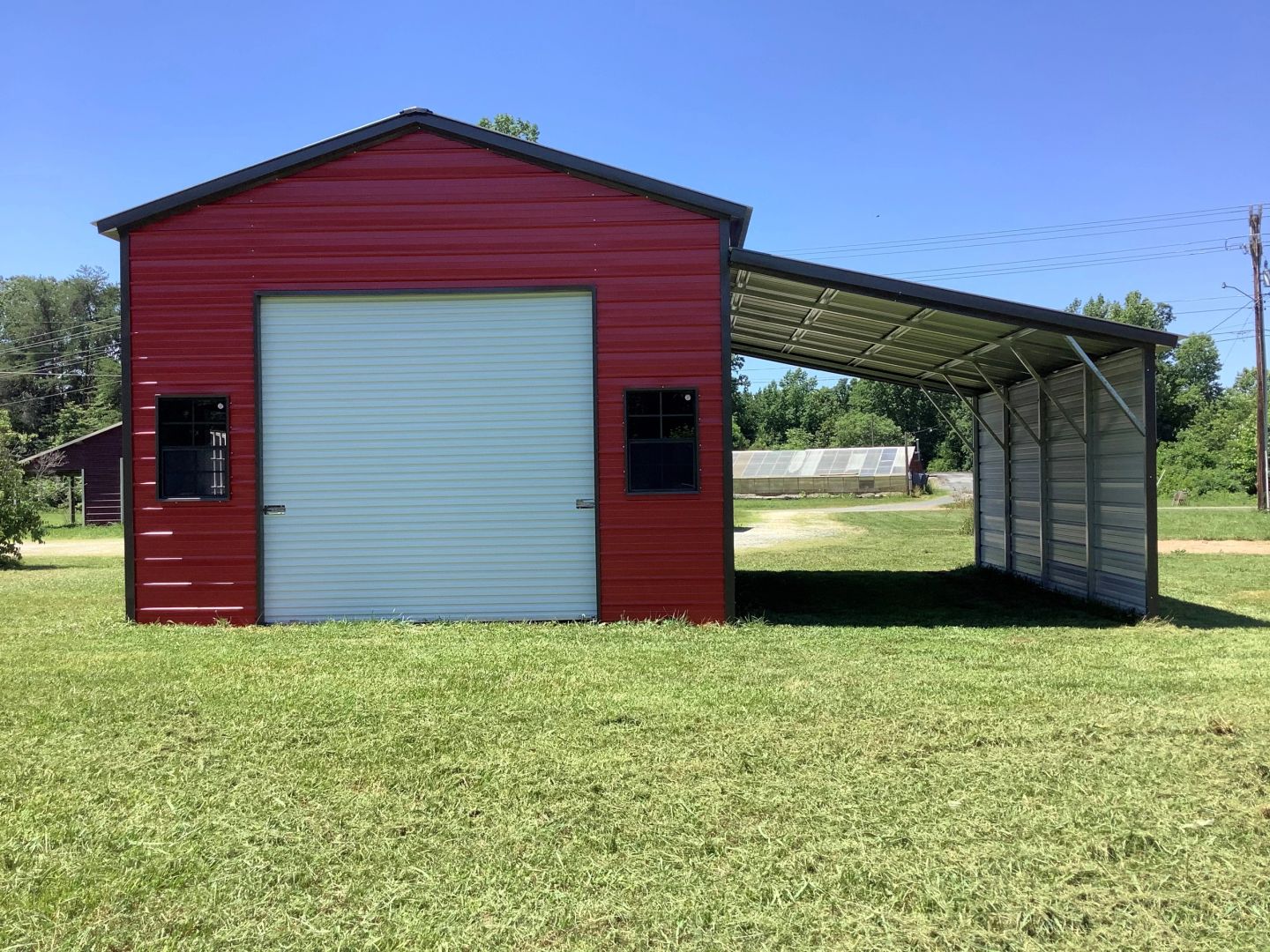 a red and white metal barn with a shed